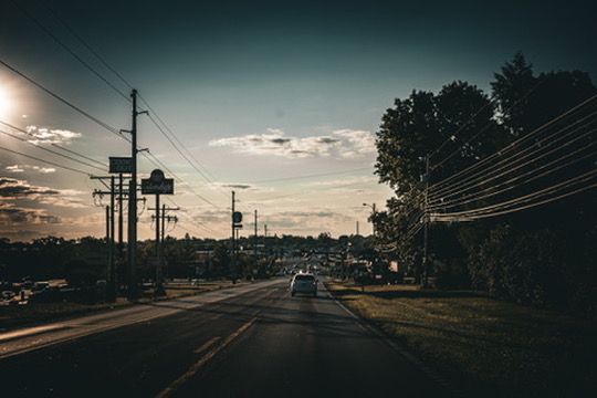 A road leading into a Kentucky town at dusk, power lines overhead